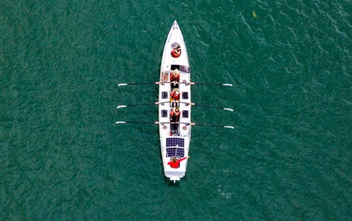 A picture of one of the ocean rowing boats on the sea taken by a drone in the sky