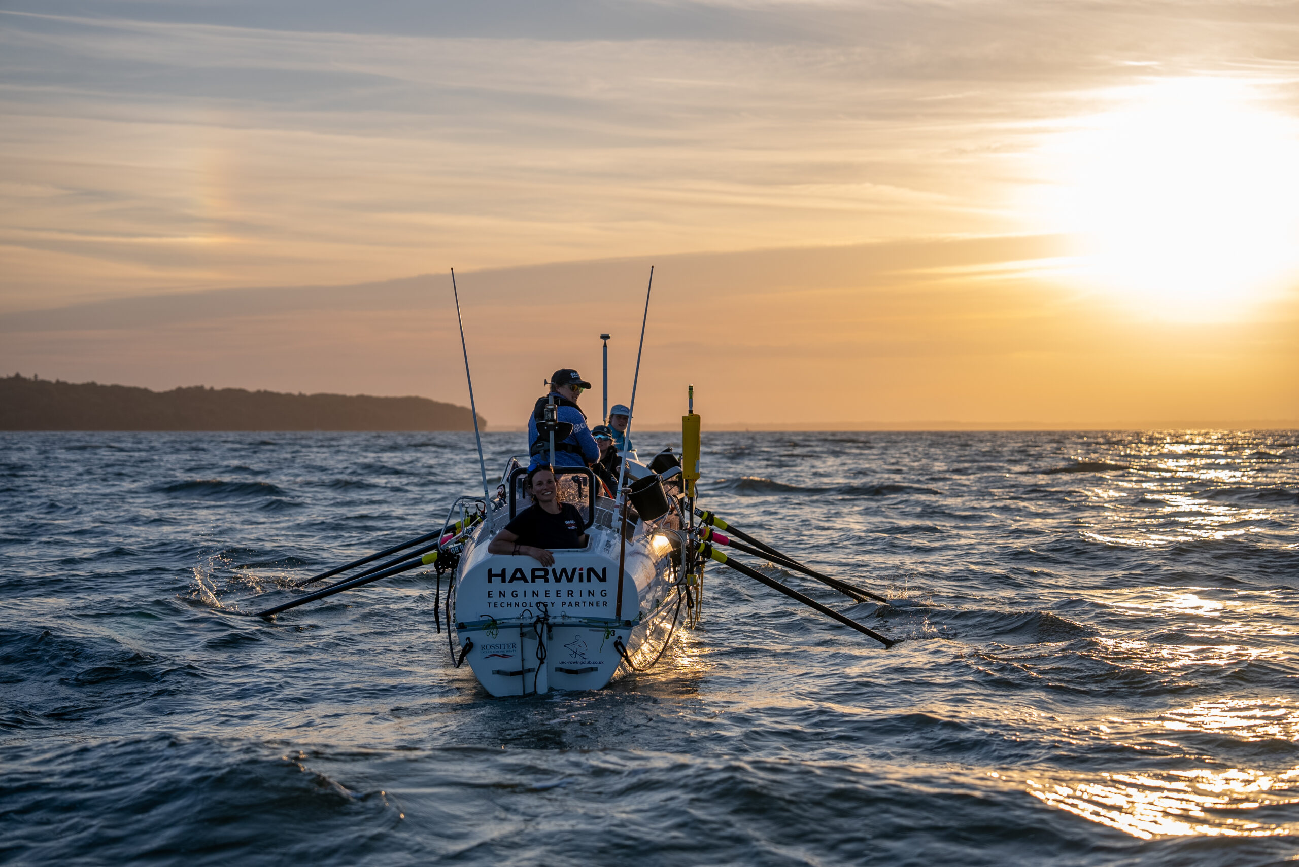 An ocean rowing boat on the water at sunset