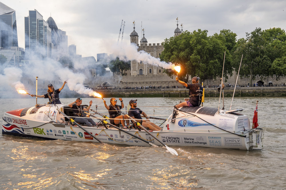 A rowing team on The Thames letting off flares
