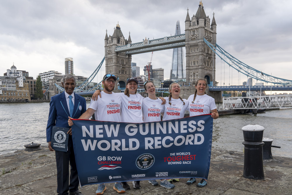A team of rowers in front of Tower Bridge, London